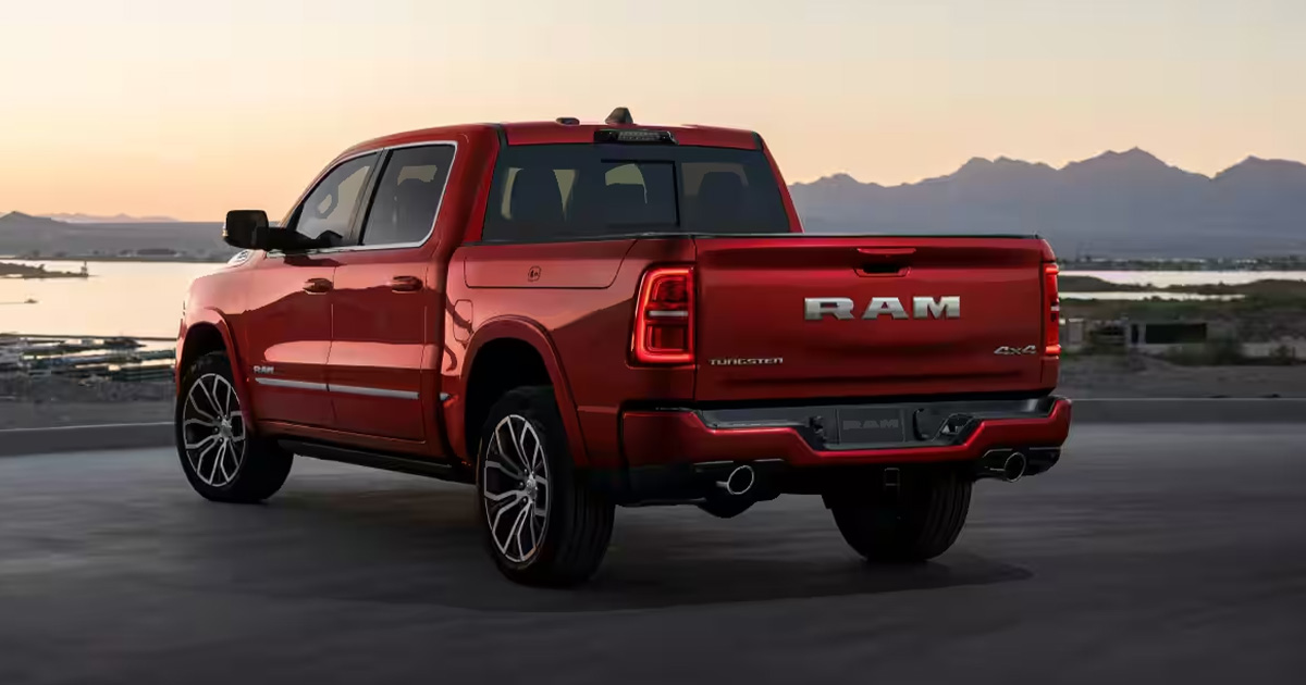 A Ram 1500 truck parked by a lake during sunset.